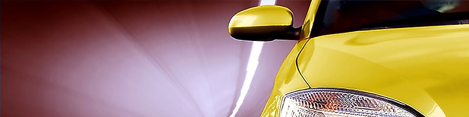 Fronten på en gul bil som kör igenom en tunnel med höger framljus och backspegel synliga