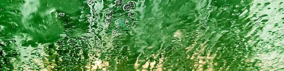 Vatten på en vindruta i en shellbiltvätt sett innifrån