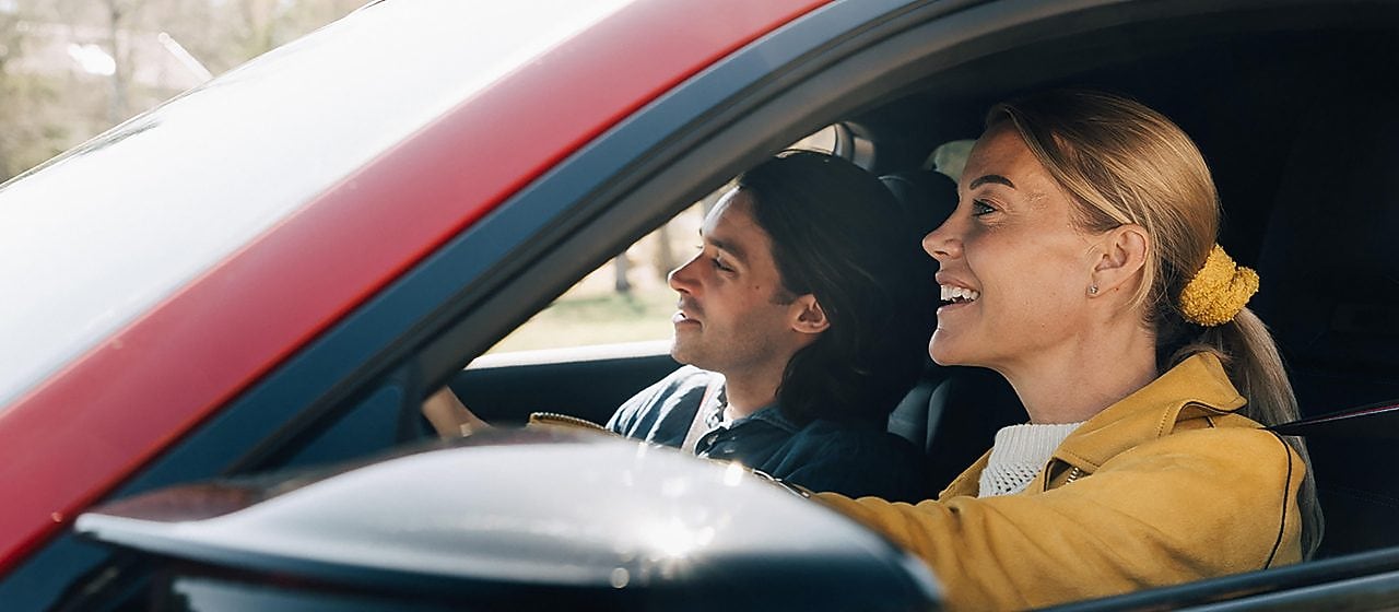 En man och en kvinna i en röd bil