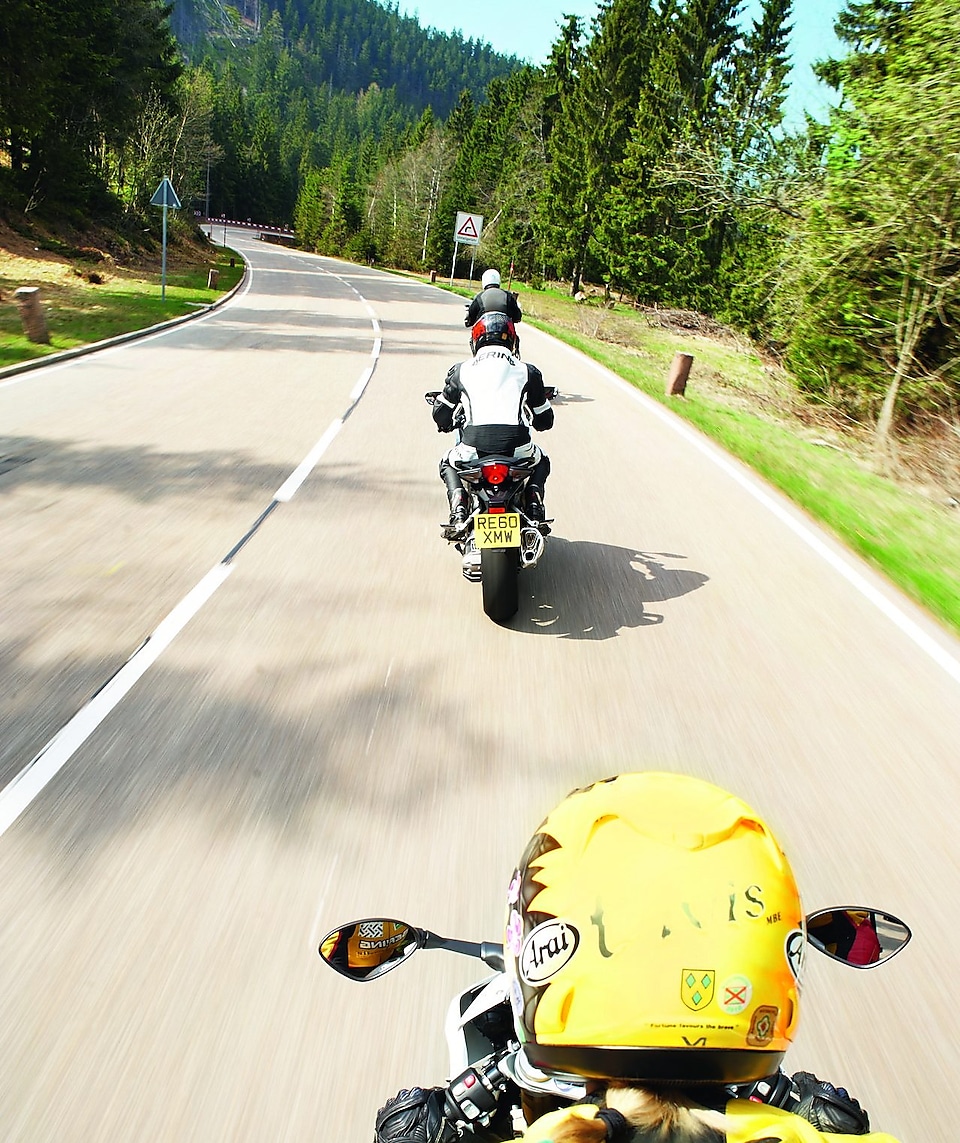 Tre motorcyklar kommer körande längs en bergsväg