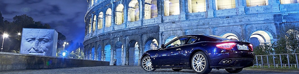 Bil parkerad utanför Colosseum i Rom på natten