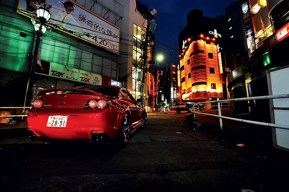 En Mazda som kör i Tokyo på natten