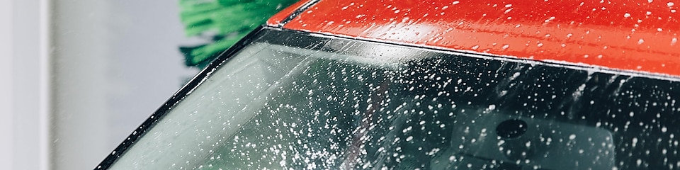 Vindrutan och ett rött tak på en bil i en biltvätt på Shell