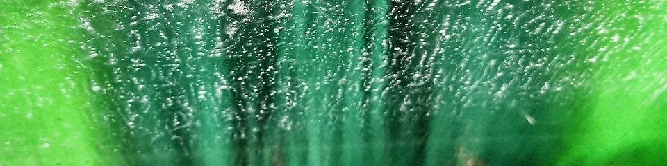 Grön tvättborste utanför vindrutan på en bil i en biltvätt på Shell