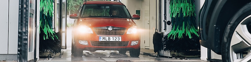 Röd bil ren och fin kör ut ur en biltvätt vid Shell
